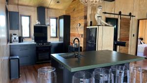 a kitchen with a sink and a counter with bar stools at Slice of paradise in Haumoana