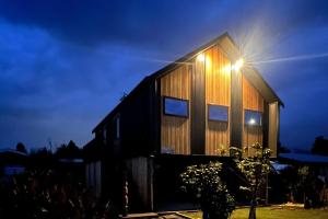 a house with a light on the side of it at Slice of paradise in Haumoana