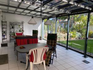 a screened in porch with a table and chairs at Home-Rose-Garden-Gästehaus kontaktloser Zugang in Düsseldorf