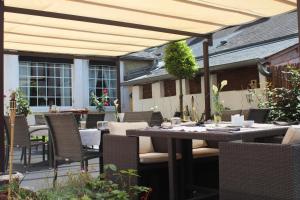 a patio with a table and chairs under an umbrella at Logis Hôtels Restaurant Les 3 Rois in Issoudun