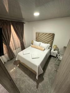 Un dormitorio con una gran cama blanca y dos ventanas. en Saman suites, en Alcalá