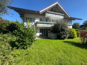 a large white house with a green yard at ciao-aschau FeWo Chiemgau Gastner in Unterwössen