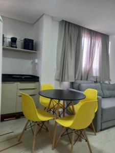 a dining room with a table and yellow chairs at Refúgio no Bessa in João Pessoa