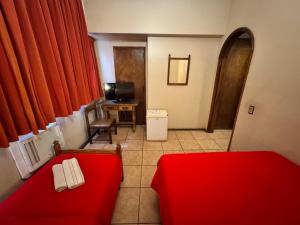 a living room with a red couch and a television at Hotel Ponte Real in São João del Rei
