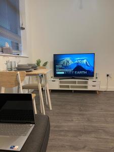 伯明翰Digbeth Luxury 1 Bed Studio Apartment的客厅配有电视和带笔记本电脑的桌子