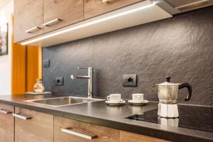 a kitchen counter with a sink and a tea kettle at Villa Erina App C3 in Ortisei +19 photos