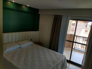 - une chambre avec un lit avec un mur vert et une fenêtre dans l'établissement Beverlly Hills, à Aquiraz 18 autres photos