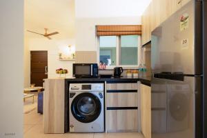a kitchen with a washing machine and a refrigerator at Modern 1BHK by Kastra Homes, Siolim in Cunchelim