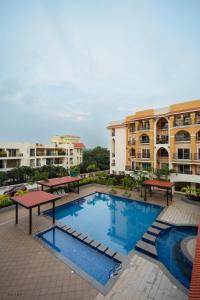 a pool in front of some apartment buildings at Modern 1BHK by Kastra Homes, Siolim in Cunchelim