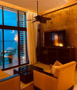a living room with a couch and a ceiling fan at Hotel "Ala Residencias" in Chetumal