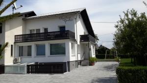 uma casa branca com uma varanda ao lado em Apartments Grom em Bled