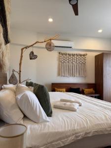 a bedroom with a bed with white sheets and pillows at Santal Tulum Condo Hotel By Marea in Tulum