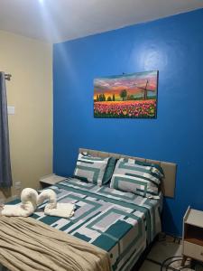 una camera da letto con un letto e un dipinto sul muro di Casa espaçosa, 6 pessoas a 15 min dos eventos COP30 a Belém