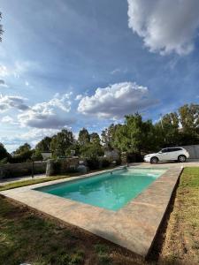 a swimming pool with a car parked next to it at Karoo Sunset Villa in Richmond
