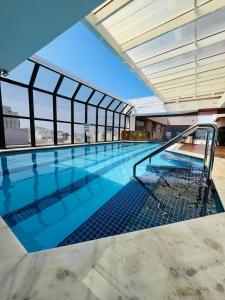 Guarujá Golden Beach 158 - Conforto com Piscina Climatizada في غوارويا: مسبح في اعلى مبنى