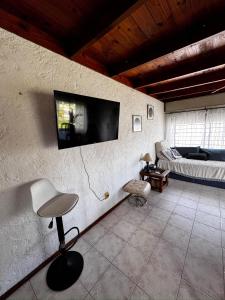 a living room with a chair and a tv on a wall at Mar 11 -ALOHA in Parque del Plata