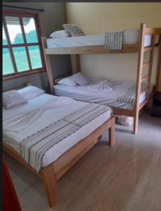 um quarto com dois beliches e uma janela em Cabaña Sol y Mar em San Antero