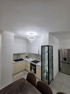 a kitchen with a stove and a sink and a refrigerator at Diana Home34 in Tirana