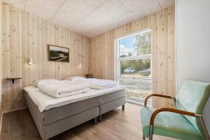 una camera da letto con un letto, una finestra e una sedia di 8959-Orsted-Klydevej-9 a Estruplund