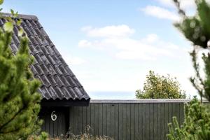 Tagholmにある2555-Romo-A-M-Listsvej-6の黒い柵と海を背景にした家