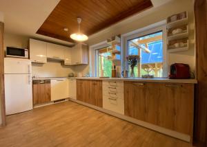 a kitchen with a white refrigerator and a window at Chalet Green Park in Stará Lesná