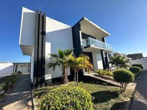 una casa bianca con palme di fronte di Projeto ajuda o seu próximo a Irati