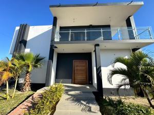 Casa bianca con balcone e palme di Projeto ajuda o seu próximo a Irati