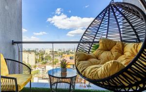 ナイロビにあるVieli Luxury Apartment with heated Pool,Gym,1 min walk to Mallのバルコニーのスイングチェアとソファ