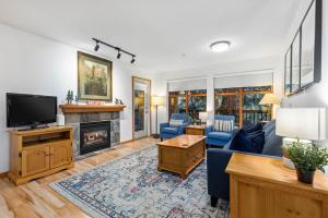 a living room with a couch and a fireplace at Steps From The Village with Pool and Hot Tub by Harmony Whistler in Whistler