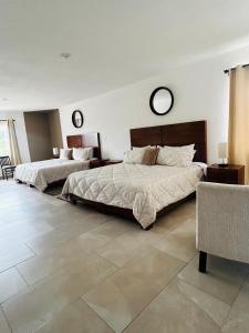 a bedroom with two beds and two mirrors on the wall at Pedernal Hotel in San Miguel de Allende