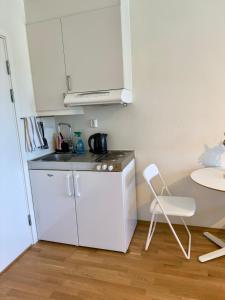 a small white kitchen with a table and a chair at Apartment perfect for work or vacation - kitchen, full bathroom, balcony in Oslo +2 photos