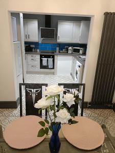 eine Küche mit einem Tisch mit einer Blumenvase in der Unterkunft #72 Stylish 3 bedroom sleeps 7 Wigan House in Pemberton