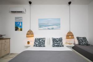 a bedroom with a bed and some pictures on the wall at Infinity Apartments in Naxos Chora