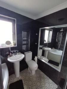 ein Badezimmer mit zwei Waschbecken und einer Toilette und einem Spiegel in der Unterkunft #72 Stylish 3 bedroom sleeps 7 Wigan House in Pemberton
