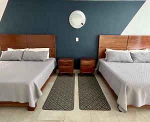 a room with two beds and a mirror on the wall at Pedernal Hotel in San Miguel de Allende