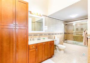 ein Badezimmer mit Waschbecken, Toilette und Spiegel in der Unterkunft Breathtaking Chalk Sound Private Pool Sunset Villa in Providenciales