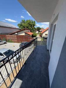 a balcony of a house with a fence and a car at Bee apartman in Odorheiu Secuiesc