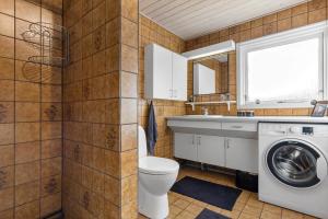 a bathroom with a toilet and a sink and a washing machine at 8580-Glesborg-Vikingebanke-7 in Bønnerup Strand