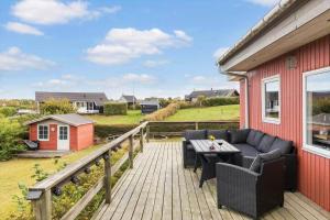 a wooden deck with a table and chairs on a house at 8580-Glesborg-Vikingebanke-7 in Bønnerup Strand