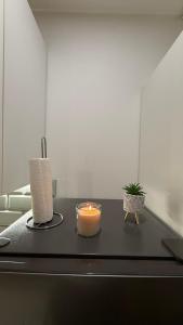 a candle and a potted plant on a table at Séjour lumineux et moderne aux portes de Paris in Gentilly