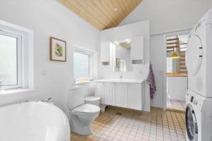 a white bathroom with a toilet and a sink at 8552-Grenaa-Polderrevsvej-17 in Grenå Strand +14 photos
