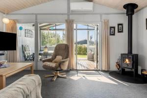 - un salon avec une chaise et un poêle à bois dans l'établissement N336-Karrebaeksminde-Cypresvaenget-69, à Enø By