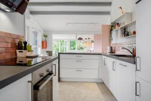 a kitchen with white cabinets and black counter tops at N337-Karrebaeksminde-Strandrylevej-11 in Enø By +13 photos