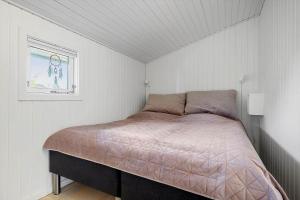 a bedroom with a bed in a white room at N337-Karrebaeksminde-Strandrylevej-11 in Enø By