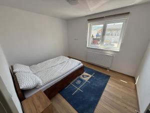 a small bedroom with a bed and a window at Bee apartman in Odorheiu Secuiesc