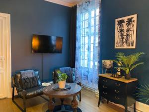 a living room with a couch and a table at Chambre bleu Chic et cosy piscine spa petit déjeuner in Varennes Vauzelles