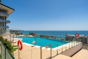 una piscina con el océano al fondo en Seaviews Reserve The Breeze, en Fuengirola
