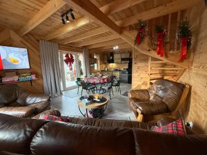 a living room with couches and a table in a cabin at #Fuleda#Giżycko Fuledzianka domek na Mazurach #bania #jacuzziklimat in Giżycko