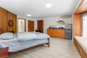 ein Schlafzimmer mit großem Bett und eine Küche in der Unterkunft Spacious and bright large suite with independent access in Delta