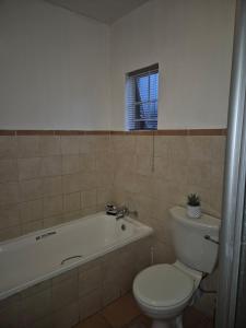 a bathroom with a toilet and a bath tub and a toilet at Mandy & Mos' Holiday Townhouse in Four Ways +19 photos
